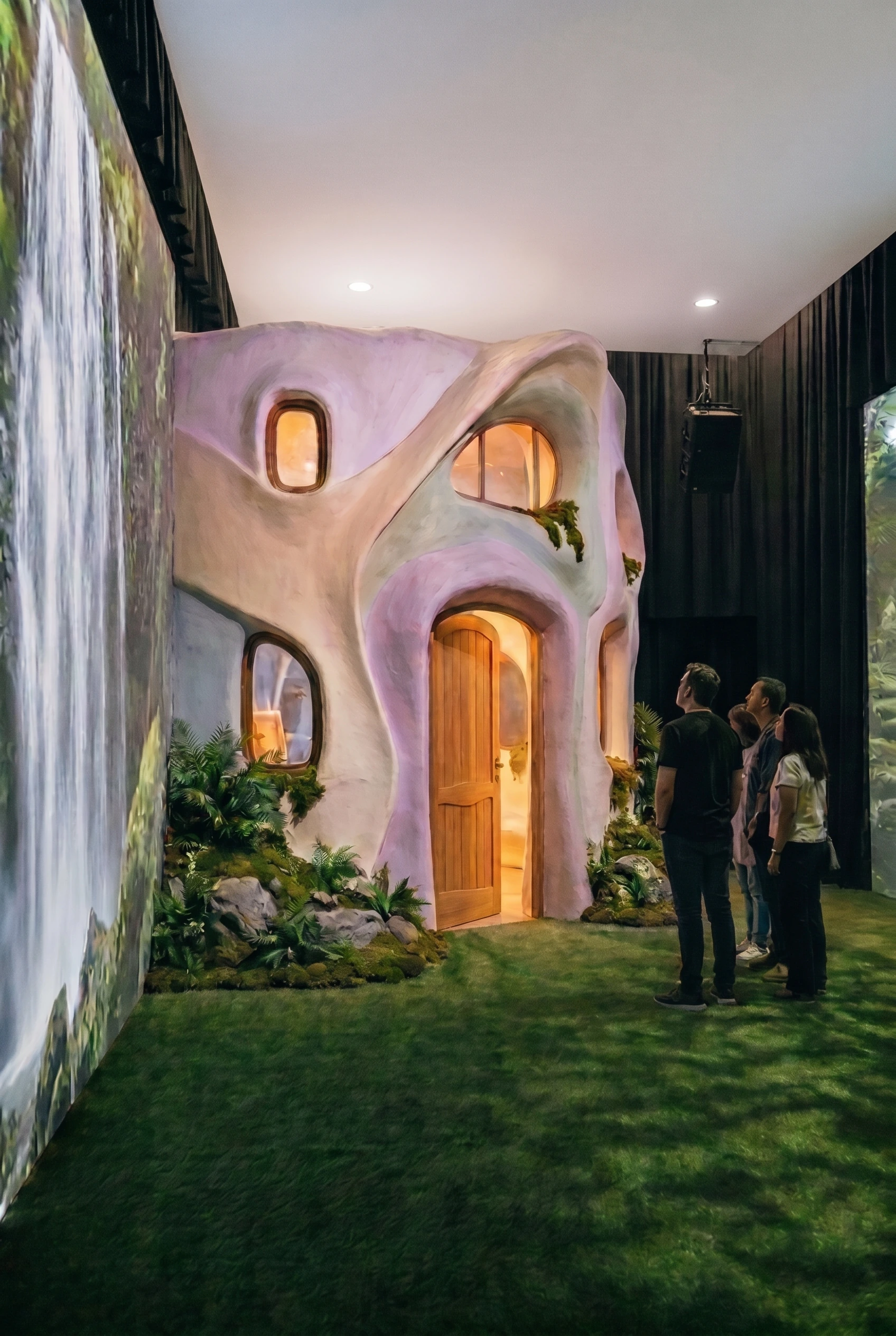 Visitors looking up at the studio beside the waterfall